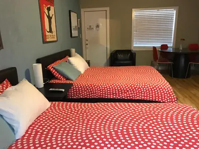 two beds with red and white sheets in a room at Sun Beach Inn in Hollywood