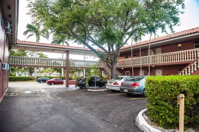 a parking lot in front of a hotel with cars parked at Gables Inn in Miami