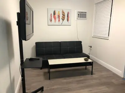 a living room with a black couch and a table at Close to Everything Miami in Miami