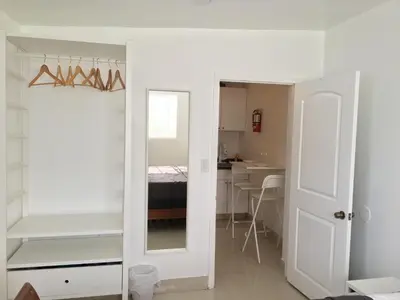 a white room with a mirror and a bedroom at Close to Everything Miami in Miami
