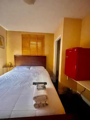a bedroom with a large bed and a red cabinet at Habitación Céntrica calle 8 Miami in Miami