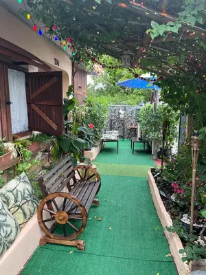 a patio with a wooden bench and an umbrella at Habitación Céntrica calle 8 Miami in Miami