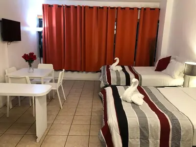 a hotel room with two beds and a table and a table and chairs at Casablanca on the beach, Oceanfront Studio Miami Beach in Miami Beach