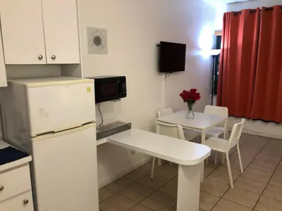 a small kitchen with a table and a white refrigerator at Casablanca on the beach, Oceanfront Studio Miami Beach in Miami Beach