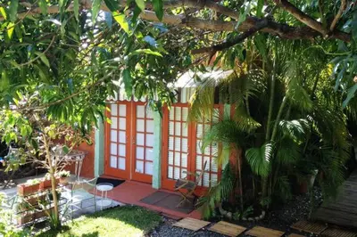 a small house with an orange door in a garden at The Wild Rose in Miami