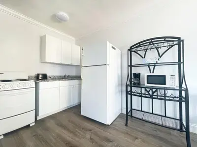 a kitchen with white cabinets and a white refrigerator at Paradise Oceanfront by HBH in Hollywood