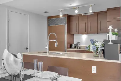a kitchen with wooden cabinets and a table and chairs at Luxury Waterfront Condo In The Urban Oasis At Icon-Brickell Free Spa in Miami