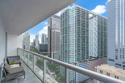 a balcony with a chair and a view of the city at Luxury Waterfront Condo In The Urban Oasis At Icon-Brickell Free Spa in Miami