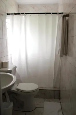 a white bathroom with a toilet and a sink at Ramona Motel in Miami