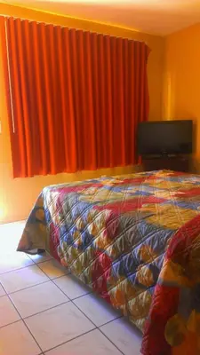 a bedroom with a bed and an orange curtain at Ramona Motel in Miami