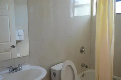 a bathroom with a toilet and a sink at Carl's El Padre Motel in Miami