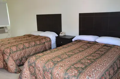 a hotel room with two beds and a telephone at Carl's El Padre Motel in Miami