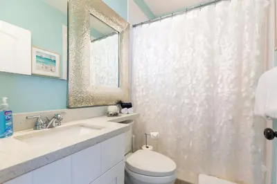 a bathroom with a toilet and a sink and a mirror at A Suite Retreat in Miami