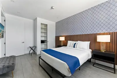 a bedroom with a large bed and a chair at MILLA South Beach in Miami Beach