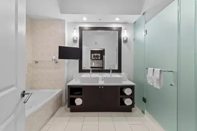 a bathroom with a sink and a tub and a mirror at Provident Doral At The Blue in Miami