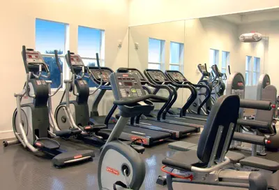 a gym with a lot of treadmills and elliptical machines at Provident Doral At The Blue in Miami