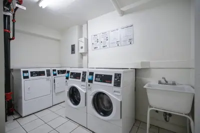 a laundry room with three washing machines and a sink at Great Apartment with beach access in Hollywood