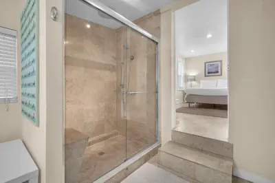 a shower with a glass door in a bathroom at Grove Bay Bungalow - 2/2 Gated Cottage-Walk to Bay in Miami