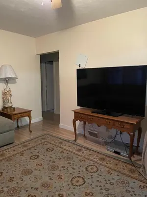a living room with a large flat screen tv on a table at House next to the golf course in Plantation