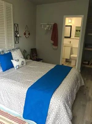 a bedroom with a blue and white bed and a bathroom at Walk to Restaurants and Shops - 5S in Miami