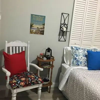 a bedroom with a bed and a chair with pillows at Walk to Restaurants and Shops - 5S in Miami