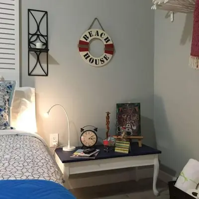 a bedroom with a bed and a table with a clock at Walk to Restaurants and Shops - 5S in Miami