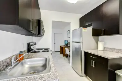 a kitchen with a sink and a refrigerator at Cottages El Portal in Miami