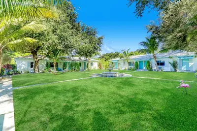 a house with a yard with a fountain and palm trees at Cottages El Portal in Miami