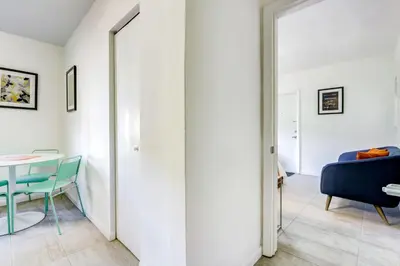 a room with a mirror and a table and a blue chair at Cottages El Portal in Miami