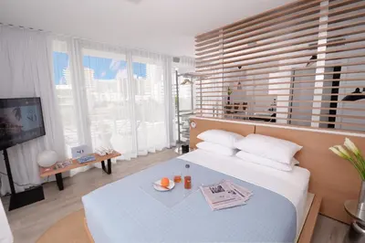 a bedroom with a bed with a television and a table at 6080 Design Hotel by Eskape Collection in Miami Beach
