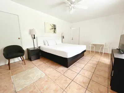 a bedroom with a bed and a chair and a table at Tropi Rock in Fort Lauderdale