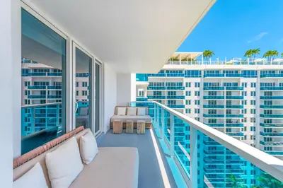 a balcony with a couch and views of buildings at Oceanview Private Condo at 1 Hotel & Homes -1544 in Miami Beach