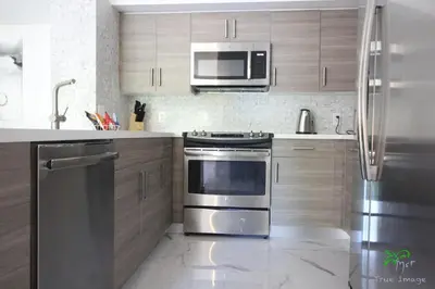 a kitchen with a stainless steel stove and a microwave at Yacht Club at Aventura 2 Bed 2 bath Luxurius Cozy Brand New in Aventura