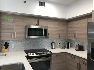 a kitchen with stainless steel appliances and wooden cabinets at Yacht Club at Aventura 2 Bed 2 bath Luxurius Cozy Brand New in Aventura