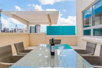 a bottle of wine on a glass table on a rooftop at 4 BDR Sweeping Bayfront Elegance in Miami