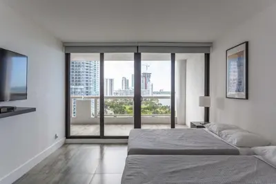 a bedroom with a bed and a large window at 4 BDR Sweeping Bayfront Elegance in Miami