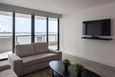 a living room with a couch and a flat screen tv at 4 BDR Sweeping Bayfront Elegance in Miami