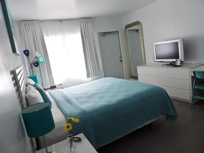 a bedroom with a blue bed and a television at Snooze in Fort Lauderdale