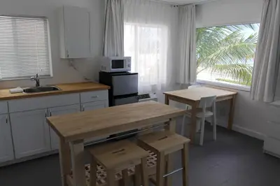 a kitchen with a wooden table and two stools at Snooze in Fort Lauderdale