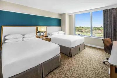 a hotel room with two beds and a window at Hilton Miami Dadeland in South Miami