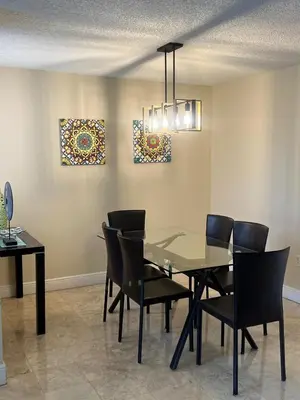 a dining room with a glass table and chairs at Renovated 2/2 Unit at Yacht Club/Aventura in Aventura