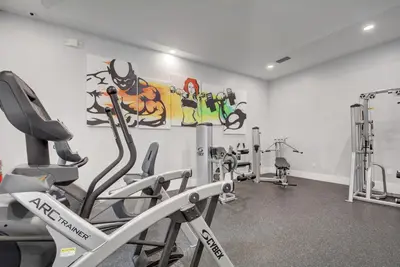 a gym with tread machines and a painting on the wall at Renovated 2/2 Unit at Yacht Club/Aventura in Aventura
