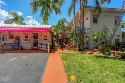 a house with a pink awning next to a yard at Richard's Motel in Hollywood