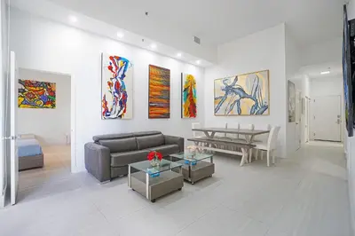 a living room with a couch and paintings on the wall at Miami Brickell 4 Bedrooms High Ceiling loft on the pool in Miami