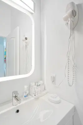 a white bathroom with a blow dryer on the wall at Miami Brickell 4 Bedrooms High Ceiling loft on the pool in Miami