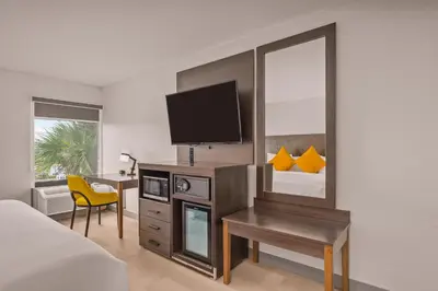 a hotel room with a bed and a desk with a television at B&B Hotel Miami Airport in Miami