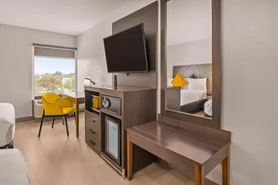 a hotel room with a television and a mirror at B&B Hotel Miami Airport in Miami
