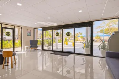 an empty lobby with chairs and windows in a building at B&B Hotel Miami Airport in Miami