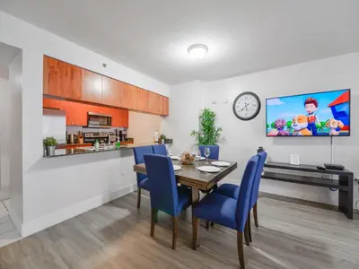 a kitchen and dining room with a table and blue chairs at Gorgeous apartment in Brickell in Miami
