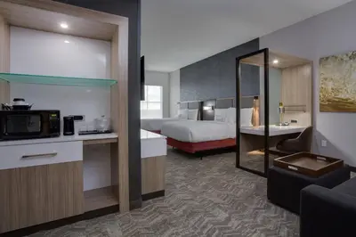 a hotel room with a bed and a living room at SpringHill Suites by Marriott Fort Lauderdale Miramar in Miramar